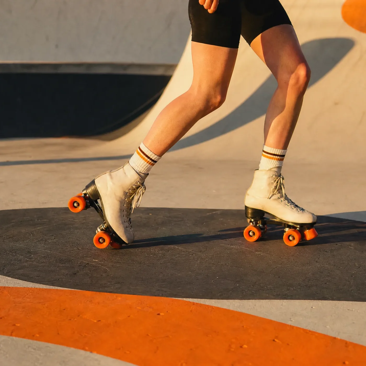 Skater gliding outdoors on a concrete skate park at golden hour